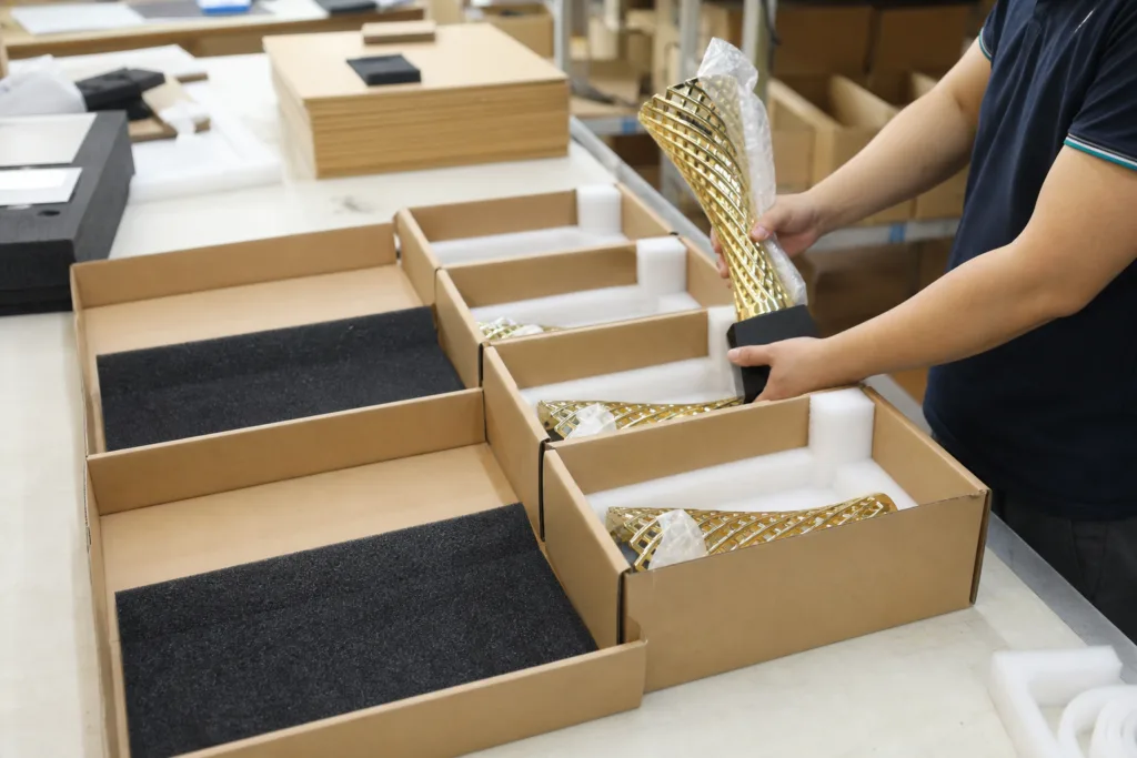 Custom trophy base assemblies secured in export cartons with foam protection