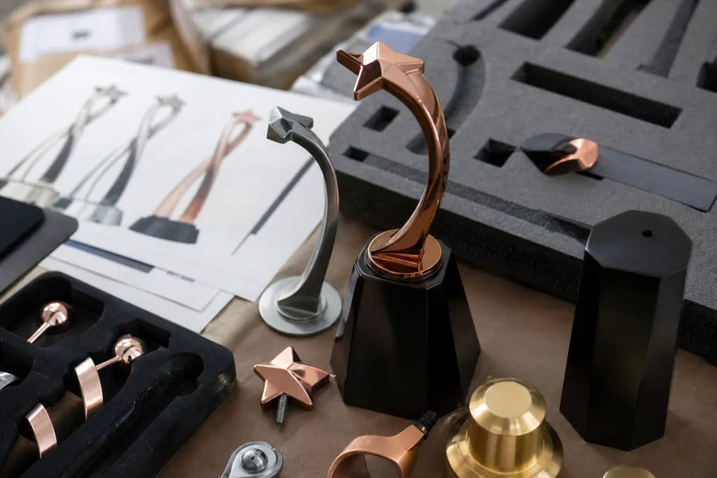 How to Write a Custom Trophy Design Brief for a Manufacturer 2 Custom metal trophy components, base options and protective packaging samples prepared for manufacturer evaluation