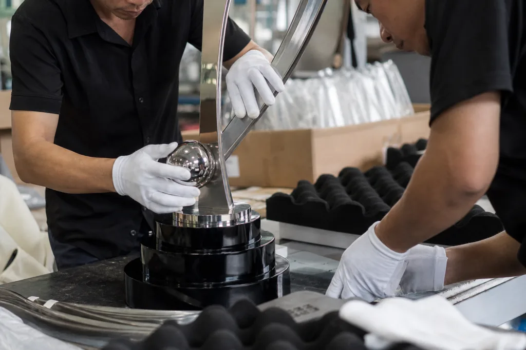 How to Specify Trophy Weight Without Overengineering the Award 2 Custom trophy base and metal body parts being assembled and checked for balance in a factory